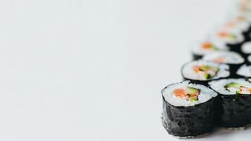 ai generado fila de Fresco Sushi rollos en un blanco antecedentes con Copiar espacio, ideal para culinario conceptos y japonés cocina foto