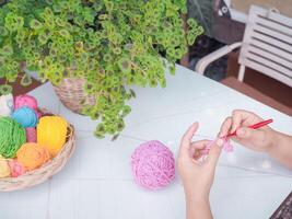 Close-up of woman hand knitting with pink wool photo