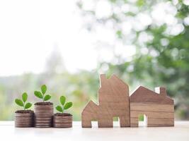 Miniature house and plants growing up on stack of coins. The concept of saving money for house, Property investment, House mortgage, Real estate. photo