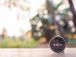 Close up compass on table in the sunset time. The concept of world tourism day, Searching the right directions and Travel photo