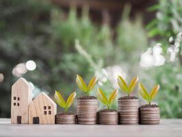 Miniature house and plants growing up on stack of coins. The concept of saving money for house, Property investment, House mortgage, Real estate. photo