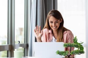 business woman using laptop at home, looking at screen, chatting, reading or writing email, sitting on couch, female student doing homework, working on research project online photo