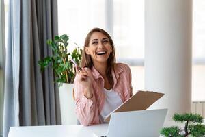 enfocado negocio mujer utilizando ordenador portátil a hogar, mirando a pantalla, charlando, leyendo o escritura correo electrónico, sentado en sofá, hembra estudiante haciendo tarea, trabajando en investigación proyecto en línea foto