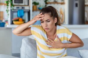 Breathing, respiratory problem, asthma attack, pressure, chest pain, sun stroke, dizziness concept. portrait of woman received heatstroke in hot summer weather, touching her forehead photo