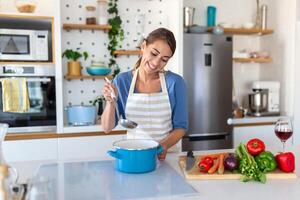 Beautiful young woman stand at modern kitchen chop vegetables prepare fresh vegetable salad for dinner or lunch, young woman cooking at home make breakfast follow healthy diet, vegetarian concept photo