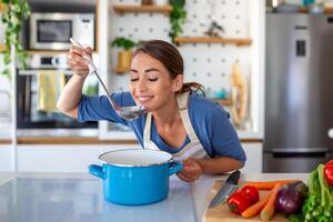 hermosa joven mujer estar a moderno cocina picar vegetales preparar Fresco vegetal ensalada para cena o almuerzo, joven mujer Cocinando a hogar hacer desayuno seguir sano dieta, vegetariano concepto foto