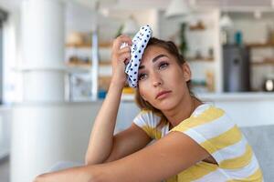 Close-up shot of a woman suffering from a headache cooling her head with a ice pack photo