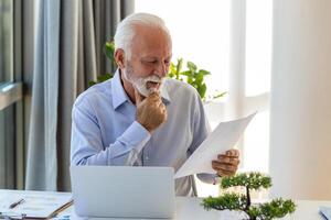 financiero tutor empresario utilizando su ordenador portátil y haciendo algunos papeleo mientras sentado a escritorio y laboral. foto