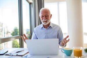 Portrait of handsome senior business coach having video call, talking to camera, explaining something. Webinar, video conferencing, online meeting concept photo