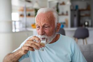 Senior man drink water from glass. Good health, lifestyle. photo