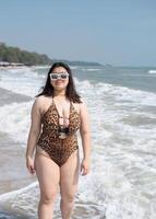 Portrait young asian woman fat chubby cute beautiful smile happy fun enjoy relax bikini swimwear body sexy front view sea beach white sand clean bluesky calm nature ocean wave water travel on holiday photo