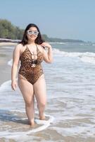 Portrait young asian woman fat chubby cute beautiful smile happy fun enjoy relax bikini swimwear body sexy front view sea beach white sand clean bluesky calm nature ocean wave water travel on holiday photo