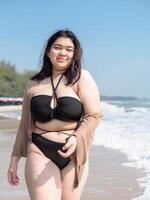 Portrait young asian woman fat chubby cute beautiful smile happy fun enjoy relax bikini swimwear body sexy front view sea beach white sand clean bluesky calm nature ocean wave water travel on holiday photo