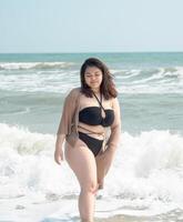 Portrait young asian woman fat chubby cute beautiful smile happy fun enjoy relax bikini swimwear body sexy front view sea beach white sand clean bluesky calm nature ocean wave water travel on holiday photo