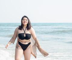 Portrait young asian woman fat chubby cute beautiful smile happy fun enjoy relax bikini swimwear body sexy front view sea beach white sand clean bluesky calm nature ocean wave water travel on holiday photo