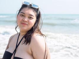 Portrait young asian woman fat chubby cute beautiful smile happy fun enjoy relax bikini swimwear body sexy front view sea beach white sand clean bluesky calm nature ocean wave water travel on holiday photo