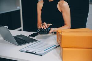 mujer de negocios comienzo pequeño negocio y exitoso SME empresarios asiático mujer hoding cajas trabajos desde hogar entregando parcelas en línea. SME entrega concepto y embalaje foto