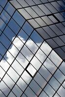 potrait shot of tilted glass structure reflecting dramatic ninbus clouds photo