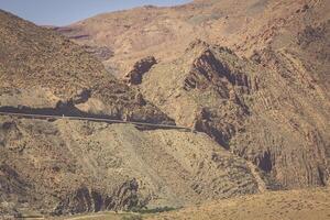 Eroded land under blue sky and white clouds, Atlas mountains, Morocco photo