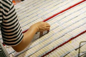 Lampang City, Thailand, 2018 - Closeup hand of people select numbers to buy Thai lotto on lotto boards in the market. photo