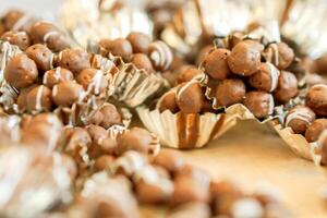 Chocolate balls with bakery wrap foil on wooden table in a bakery shop. photo
