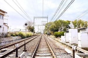 perspectiva ver de metal y gres ferrocarriles con eléctrico armarios y cable en brillante azul cielo antecedentes. foto