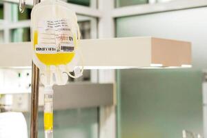 Closeup blood platelet in a medical bag hanging on a pole and transferring to a sick newborn baby at NICU wards in the hospital. photo