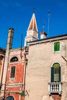 el de colores casas cerca el antiguo propensión Iglesia torre en burano isla - Venecia, Italia foto