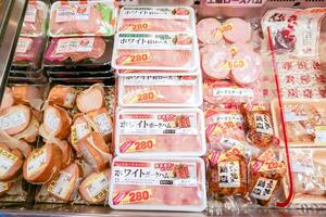 Osaka ciudad, Japón, 2018 -de cerca nalgas y procesada carne en paquetes para rebaja en Japón supermercado congelador. foto