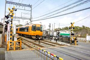 Nara city, Japan, 2018 - Closeup and stop motion of Nara local train was leaving the Nara train station and going through a road under bright blue sky. photo