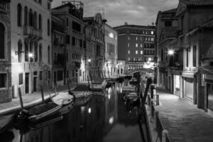 view into a small canal in Venice at night photo