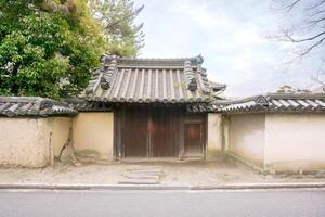 Ancient and old Japanese house gate in Nara, Japan under bright blue sky. photo