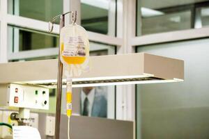 Closeup blood platelet in a medical bag hanging on a pole and transferring to a sick newborn baby at NICU wards in the hospital. photo