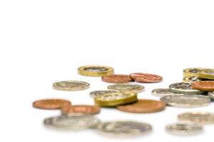 British currency coins laid out scattered and crop on white background. photo