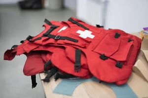 several red body armor for medics on the table photo