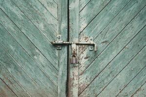 old metal lock on a wooden door with cracked paint photo