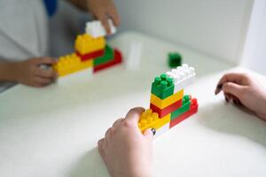 un pequeño niño obras de teatro con un constructor mientras edificio foto