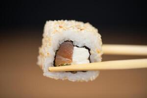 delicious traditional Japanese sushi and rolls on a plate holding chopsticks photo