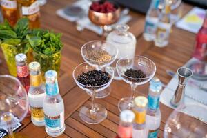 many different ingredients on the bartender's table for making alcoholic cocktails photo