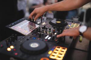 a DJ plays music on a controller at a party photo