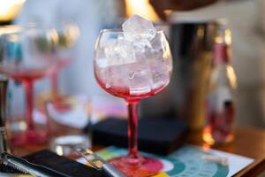 el barman prepara un alcohólico cóctel por torrencial hielo cubitos dentro un vaso foto
