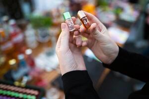 holding small glass jars with different scents in their hands photo