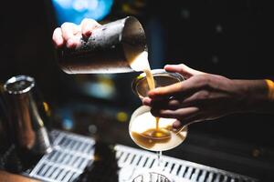 the bartender prepares a beautiful alcoholic cocktail at the bar counter photo