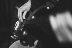 hands of a guitarist, a musician plays the bass guitar photo