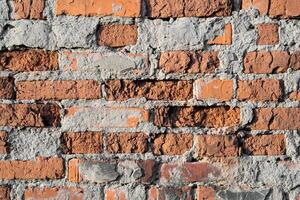 texture of old cracked and destroyed red brick wall photo