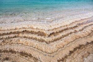 View of Dead Sea coastline at sunset time in Jordan. Salt crystals at sunset. Dead sea landscape with mineral structures. photo