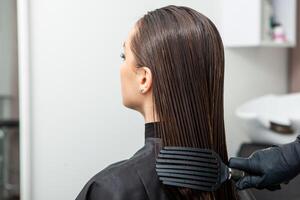 retrato de un hermosa mujer con largo marrón Derecho pelo en un belleza salón. foto