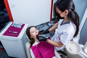 Dentist examining teeth of a young woman patient in a dental clinic. Dentistry concept. Dentist and patient in the dental office. photo