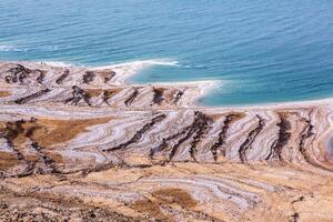 View of Dead Sea coastline at sunset time in Jordan. Salt crystals at sunset. Dead sea landscape with mineral structures. photo