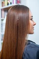 Portrait of a beautiful woman with long brown straight hair in a beauty salon. photo